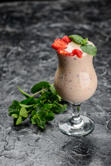 strawberry milk drink in a glass on the table with mint
