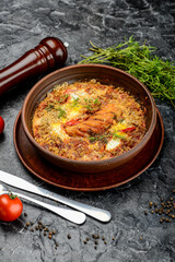 baked chicken with vegetables, greens and an egg in a ceramic pan, vertical photo
