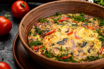 omelette with vegetables and greens in a ceramic pan, vertical photo
