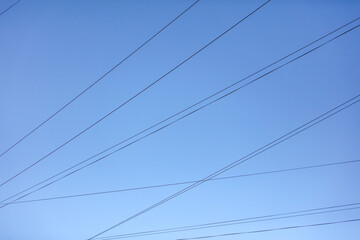 Electric wires against the blue sky. Background