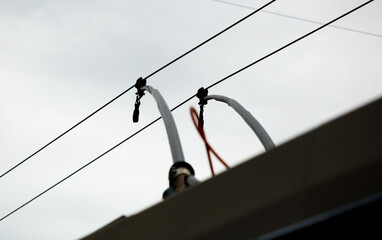 Wires of a trolleybus against a gray sky.