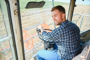 Farmer driving combine and harvesting crop.