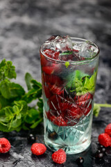 berry lemonade in a glass on the table with berries

