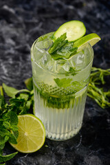 mojito cocktail in a glass on a dark background with greens vertical photo
