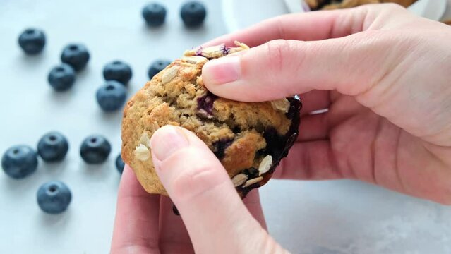 Vegan oatmeal, banana, blueberry muffin in woman hands. Plant based dessert.