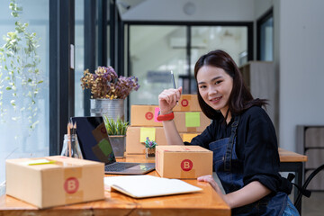 Freelance woman working at home with Online Parcel delivery. SME and packaging delivery concept