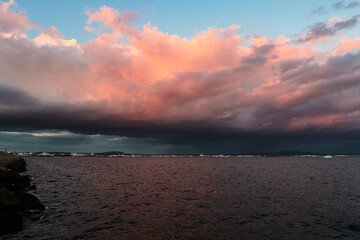 Obraz premium sunset with rain clouds on the rocky promenade of the west dyke in mallorca