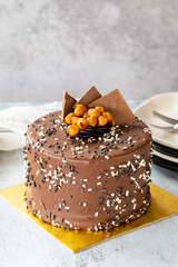 Birthday cake with croquant on gray background. Chocolate covered cake with croquant and cream inside. close up