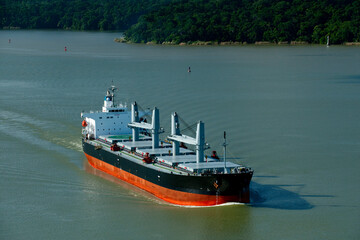 Aerial view of  grain cargo ship in transit crossing Gatun lake in the Panama Canal. - stock photo