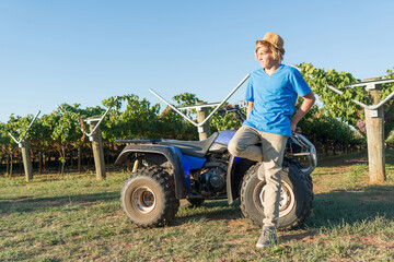 Young farmer standing near quad bike