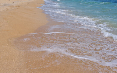 Clear emerald green sea with white foam