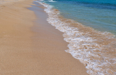 Clear emerald green sea with white foam