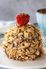 Hazelnut, strawberry and chocolate cake on gray background. Fruit and cream cake covered with chocolate on the outside. close up
