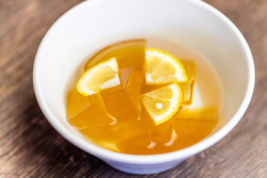 プルプルとした食感のゼリーにレモンを添えた、台湾の定番涼感スイーツ「愛玉子（オーギョーチー）」。さっぱりとした喉越しと爽やかな酸味が楽しめる、夏にぴったりのデザート紹介や台湾旅行の販促に最適な高品質素材です。 | Refreshing Taiwanese Aiyu jelly dessert with lemon slices.