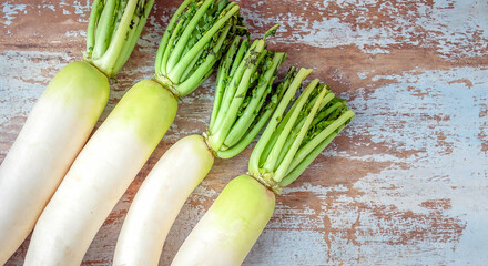 Top view of fresh white radish vegetable placed on an old wooden background.raw radish