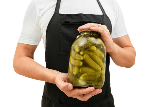 Jar with homemade pickled cucumbers in the hands of cooks isolated on white