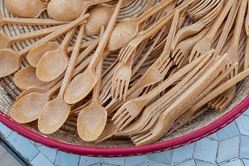 Non-plastic, biodegradeable, single-use spoons and forks set out for guests at a banquet.