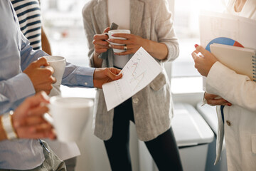 Close up of diverse coworkers analyzing sales report while having break in office