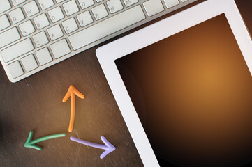 Blank digital tablet with arrow and keyboard on desk. Copy space concept and input text idea