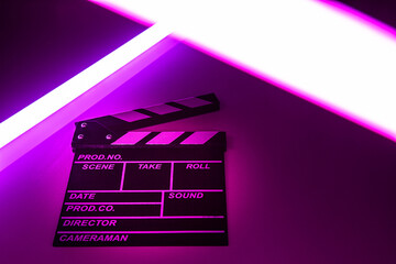 Clapperboard movie slate on Glowing neon lighting background. video director making cinema film....