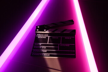 Clapperboard movie slate on Glowing neon lighting background. video director making cinema film. Film clapper design element. filmmaker clapperboard to make video film