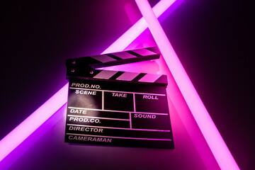 Clapperboard movie slate on Glowing neon lighting background. video director making cinema film. Film clapper design element. filmmaker clapperboard to make video film