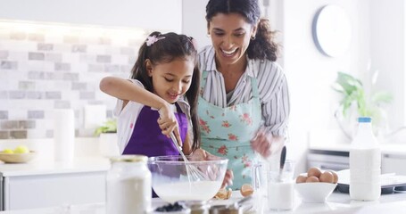 Mother and child cooking and baking a cake, dessert and breakfast cookies or food in home kitchen together. Cute, fun and happy girl with smile helping, bonding and learning from parent, woman or mom - Powered by Adobe