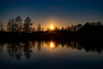 Obraz premium Zachód słońca nad jeziorem