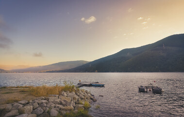 Jezioro, góry podczas wschodu słońca. Ciepły letni poranek nad jeziorem w górach.