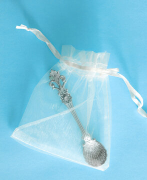 Christening Gift For A Baby Boy With A Decorative Silver Spoon Wrapped In A See Through Drawstring Gift Bag Viewed From Above