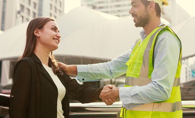 Obraz premium Male engineers shake hands to congratulate female employees for achieving their goals.
