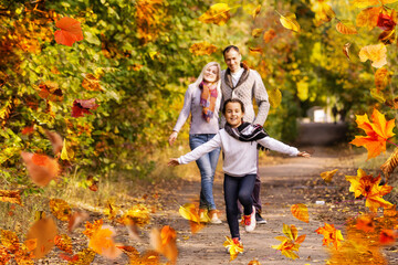 Family playing in autumn park having fun