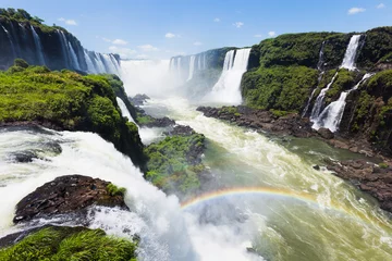 Fotobehang Spectacular view of Iguazu Falls on a sunny day, National Park in Brazil. The closest view of the waterfalls making a lovely rainbow © Nina Abrevaya