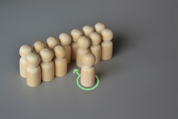 Selective focus image of one wooden doll join the group. New member, hiring, filling a vacancy...