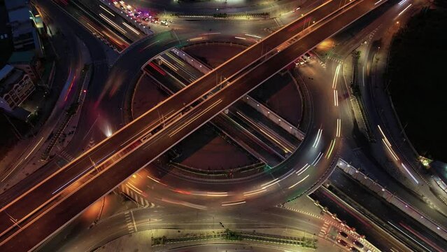 aerial view, Hyperlapse time-lapse of car traffic transportation above circle roundabout road in Asian city. Drone aerial view fly in circle, high angle. Public transport or commuter city life concept