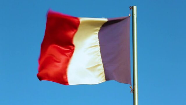 The national flag of France waving with slow motion in a blue sky
