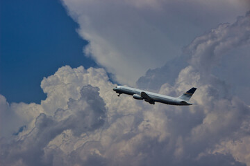 plane leaving the terminal between clouds