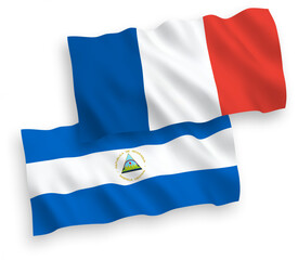 National vector fabric wave flags of France and Nicaragua isolated on white background. 1 to 2 proportion.