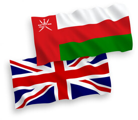 National vector fabric wave flags of Great Britain and Sultanate of Oman isolated on white background. 1 to 2 proportion.