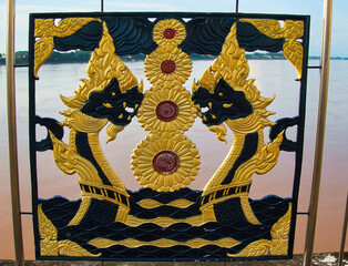 Decoration of black and gold nagas (mythical serpents) of the metal fence along the Mekong...