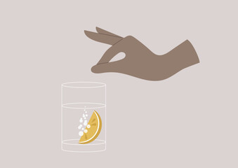 Hand putting a slice of lemon into a glass of sparkling water, summer refreshments