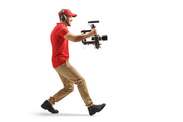 Full length profile shot of a camera operator using a stabilizer and recording with camera