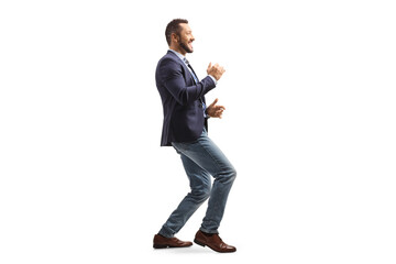 Full length profile shot of a happy professional man in suit and jeans dancing