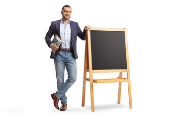 Full length portrait of a male teacher standing next to a blackboard