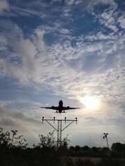Airplane landing in the sunset. Clouds in the sky