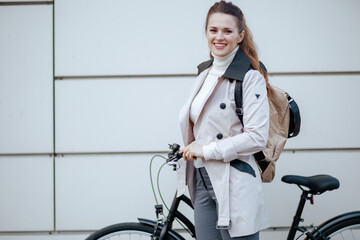 happy stylish woman with bicycle outside on city street