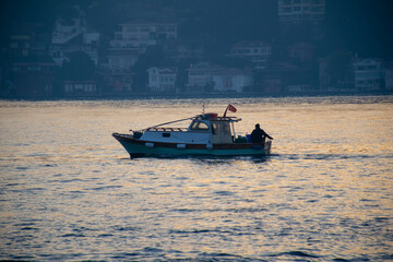 Men on a boat in Bosphorus waters in Istanbul. Fisherman in boat in Istanbul. Turkish fisherman sailing in boat in sea. - Powered by Adobe