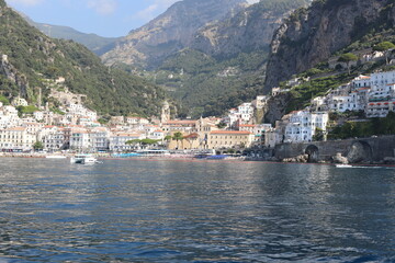 Fototapeta na wymiar Scenic Amalfi Coast view. Beautiful seascape with yacht near shore in the sea. Modern sailboat on a sunny summer day. Sailing near coastline in the Mediterranean Sea.