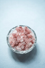 Fototapeta na wymiar Himalayan pink salt in glass bowl placed on blue background.