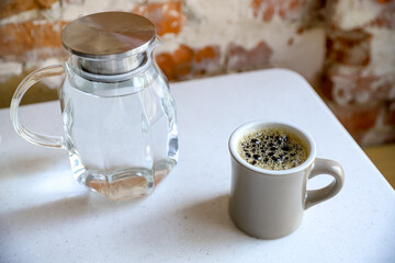 A cup of filter coffee served in a third-wave coffee-shop with a carafe of water